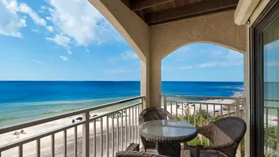 a balcony with a table and chairs and the beach at Dune Villas 5B - Sand In My Shoes in Santa Rosa Beach