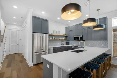 a kitchen with a large white counter and blue cabinets at Après Sea in Seacrest