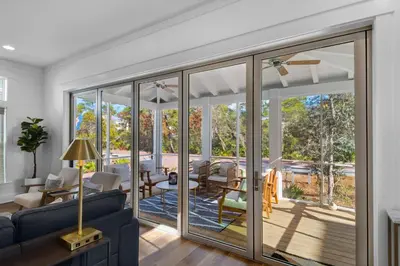 a living room with sliding glass doors leading to a patio at Après Sea in Seacrest