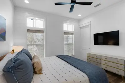a bedroom with a bed and a ceiling fan at Après Sea in Seacrest