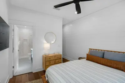 a bedroom with a bed and a mirror and a bathroom at Après Sea in Seacrest