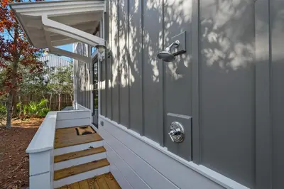 a front porch with a white door and stairs at Après Sea in Seacrest