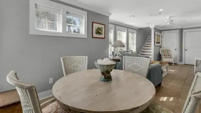 a dining room and living room with a table and chairs at Intensive Care in Santa Rosa Beach