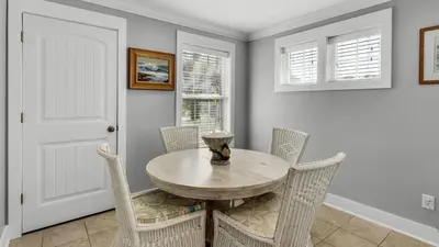 a dining room with a wooden table and chairs at Intensive Care in Santa Rosa Beach