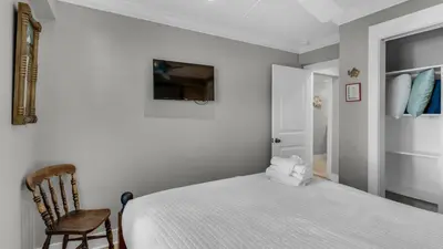 a bedroom with a white bed and a chair at Intensive Care in Santa Rosa Beach