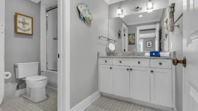 a white bathroom with a toilet and a sink at Intensive Care in Santa Rosa Beach