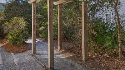 a group of wooden poles with a sign on a sidewalk at Emerald Rose in Santa Rosa Beach