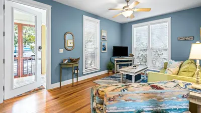 a living room with blue walls and a ceiling fan at Emerald Rose in Santa Rosa Beach