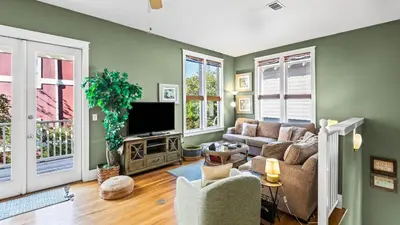 a living room with a couch and a tv at Emerald Rose in Santa Rosa Beach