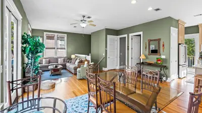 a living room with green walls and a dining room at Emerald Rose in Santa Rosa Beach