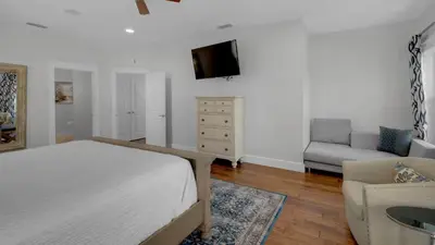 a bedroom with a bed and a chair and a television at 3 Mermaids Haven in Santa Rosa Beach