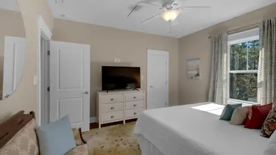 a bedroom with a bed and a flat screen tv at 3 Mermaids Haven in Santa Rosa Beach