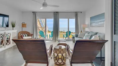 a living room with a couch and a table and chairs at Blue Tide 6A in Panama City Beach