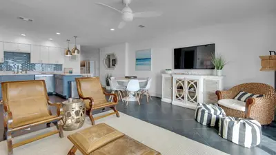 a living room filled with furniture and a kitchen at Blue Tide 6A in Panama City Beach