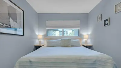 a white bedroom with a large bed with two lamps at Blue Tide 6A in Panama City Beach