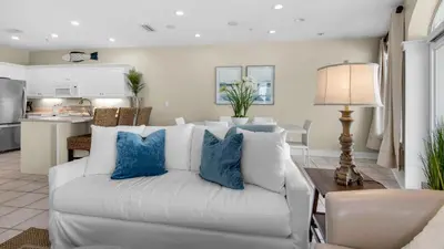a living room with a white couch and blue pillows at Monterey Condos B402 in Panama City Beach