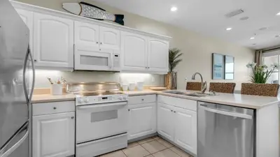 a white kitchen with white cabinets and a sink at Monterey Condos B402 in Panama City Beach