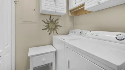 a white laundry room with a washer and dryer at Monterey Condos B402 in Panama City Beach
