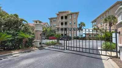 a gate in front of a house with a building at Monterey Condos B402 in Panama City Beach