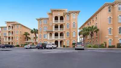 a large building with cars parked in a parking lot at Monterey Condos B402 in Panama City Beach
