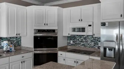 a kitchen with white cabinets and stainless steel appliances at Seaview I Unit 200 in Santa Rosa Beach