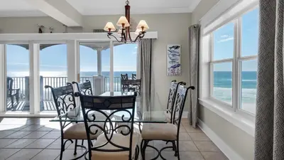 a dining room with a table and views of the ocean at Seaview I Unit 200 in Santa Rosa Beach