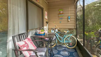 a bike parked on a porch with a table and chairs at Cassine Gardens 219 - Flamingo Retreat in Santa Rosa Beach