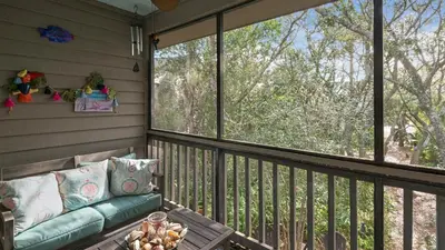 a screened in porch with a couch on the balcony at Cassine Gardens 219 - Flamingo Retreat in Santa Rosa Beach
