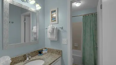 a bathroom with a sink and a mirror and a shower at Cassine Gardens 219 - Flamingo Retreat in Santa Rosa Beach