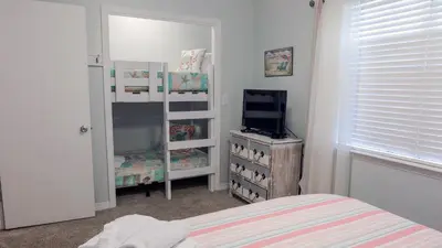 a bedroom with a bed and a tv and a dresser at Cassine Gardens 219 - Flamingo Retreat in Santa Rosa Beach