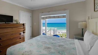 a bedroom with a bed and a view of the ocean at Paradise Cottage Too in Santa Rosa Beach