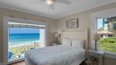 a bedroom with a bed and a view of the ocean at Paradise Cottage Too in Santa Rosa Beach