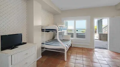 a living room with a bunk bed and a television at Paradise Cottage Too in Santa Rosa Beach