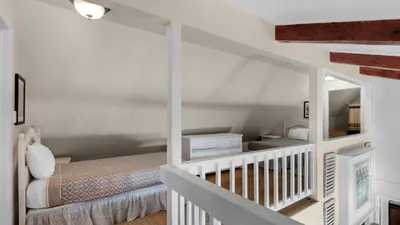 a white bedroom with a bed and a mirror at Paradise Cottage Too in Santa Rosa Beach