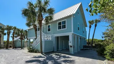 a blue house with palm trees in front of it at Paradise Cottage Too in Santa Rosa Beach