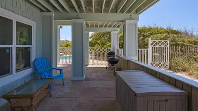a porch with a bench and a grill at Paradise Cottage Too in Santa Rosa Beach