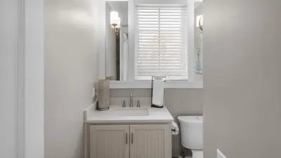 a white bathroom with a sink and a window at Walking on Sunshine - Benchmark Management in Panama City Beach