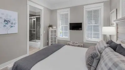 a bedroom with a large bed and windows at Walking on Sunshine - Benchmark Management in Panama City Beach
