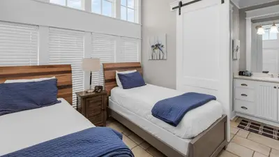 a bedroom with two beds with blue and white sheets at Walking on Sunshine - Benchmark Management in Panama City Beach