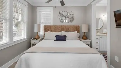 a bedroom with a large bed and two windows at Walking on Sunshine - Benchmark Management in Panama City Beach