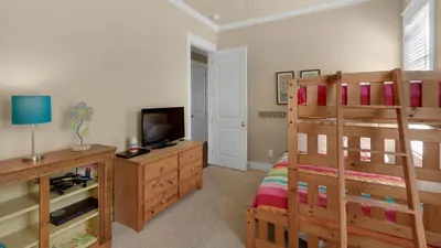 a bedroom with a bunk bed and a television at Ocean Breeze in Santa Rosa Beach