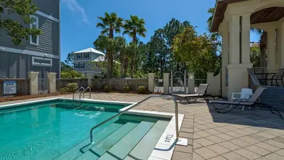 a swimming pool in a yard next to a house at Ocean Breeze in Santa Rosa Beach