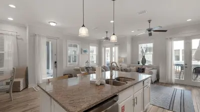 a kitchen with a counter top and a living room at Our Happy Place in Inlet Beach