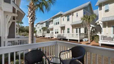 a balcony with two chairs and condos at Our Happy Place in Inlet Beach