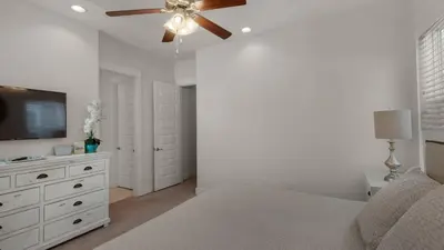 a bedroom with a bed and a ceiling fan at Our Happy Place in Inlet Beach