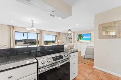 a kitchen with a stove and a living room at Capistrano E101 in Seacrest