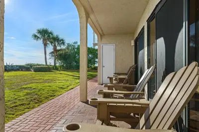a row of chairs sitting on the porch of a house at Capistrano E101 in Seacrest