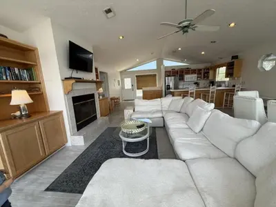 a living room with a white couch and a fireplace at All's Well in Santa Rosa Beach