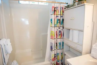 a bathroom with a shower curtain with a bath tub at All's Well in Santa Rosa Beach