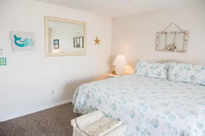 a bedroom with a bed and a mirror at All's Well in Santa Rosa Beach